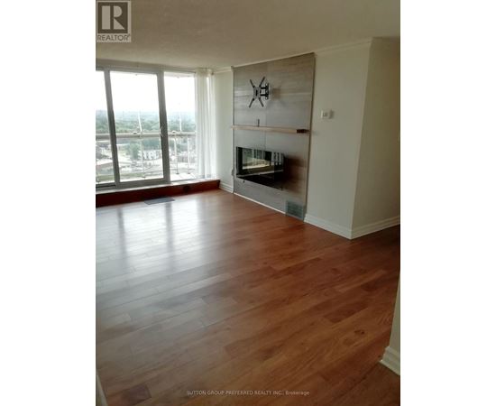 A living room with wood floors and a fireplace.
