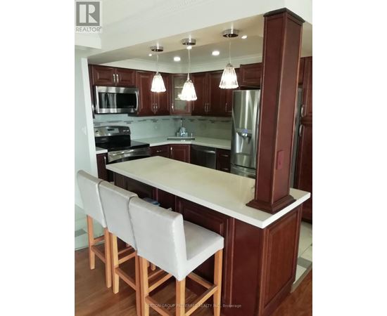 A kitchen with brown cabinets and a white island.