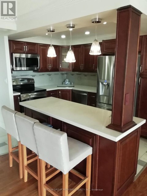 A kitchen with brown cabinets and a white island.