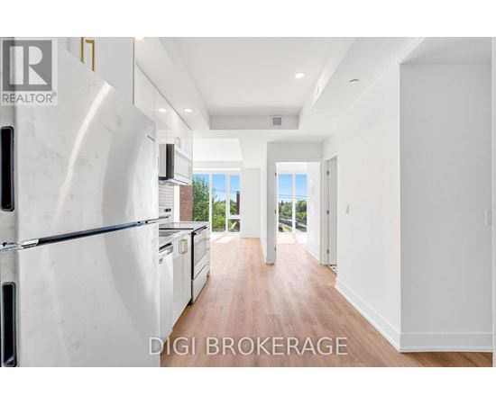 A modern kitchen with a refrigerator and a view of the outdoors.