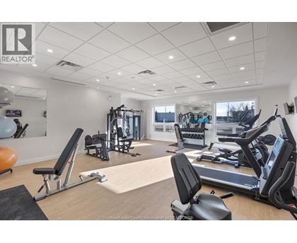 A gym with a variety of equipment including treadmills, weights, and exercise balls.