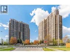 Two tall buildings are situated next to each other with a street in between.