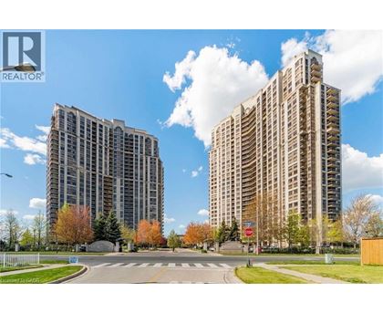 Two tall buildings are situated next to each other with a street in between.