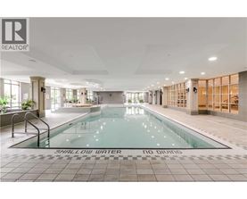 A large indoor swimming pool with the words "SHALLOW WATER" on the bottom.