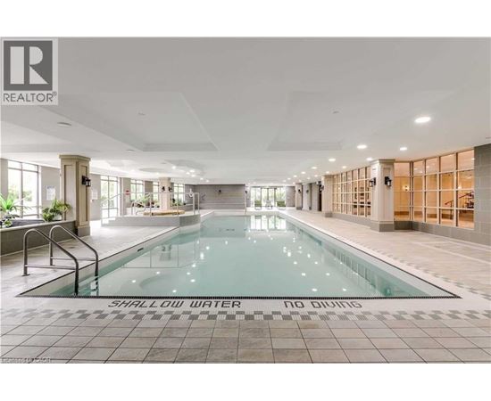 A large indoor swimming pool with the words "SHALLOW WATER" on the bottom.