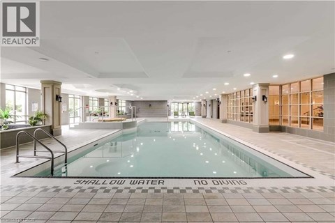 A large indoor swimming pool with the words "SHALLOW WATER" on the bottom.