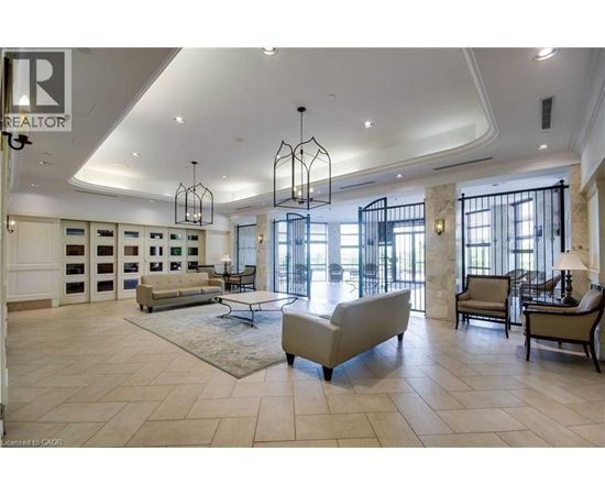 A spacious living room with a large sofa and a chandelier.