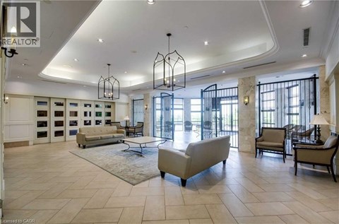 A spacious living room with a large sofa and a chandelier.