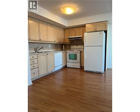 A kitchen with wooden floors and white appliances.