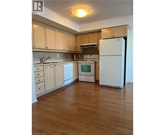 A kitchen with wooden floors and white appliances.