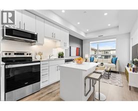 A modern kitchen with white cabinets and stainless steel appliances.