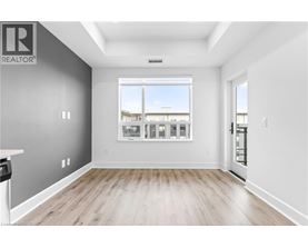 A spacious room with a large window and wooden flooring.