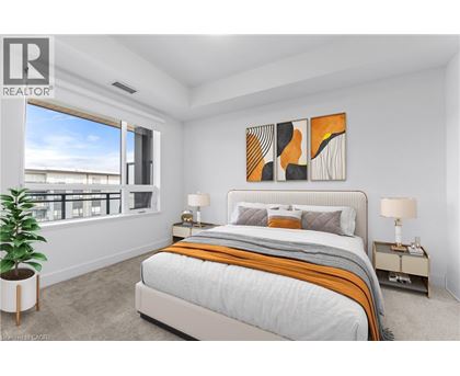 A bedroom with a large bed, a potted plant, and a painting on the wall.
