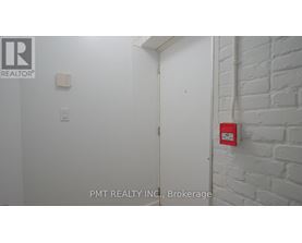 A white door with a red fire alarm on the wall.