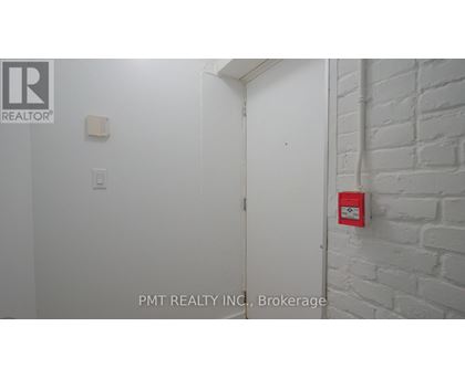 A white door with a red fire alarm on the wall.