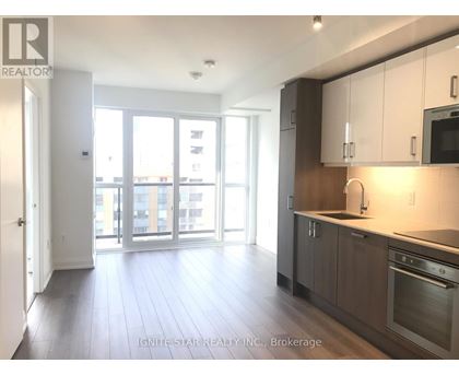 A kitchen with white cabinets and a stainless steel oven.
