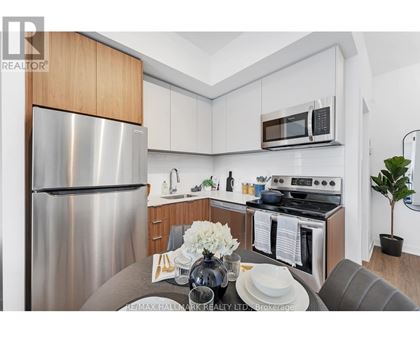 A modern kitchen with a stainless steel refrigerator and a dining table set for two.