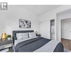 A bedroom with a large bed and a painting on the wall.