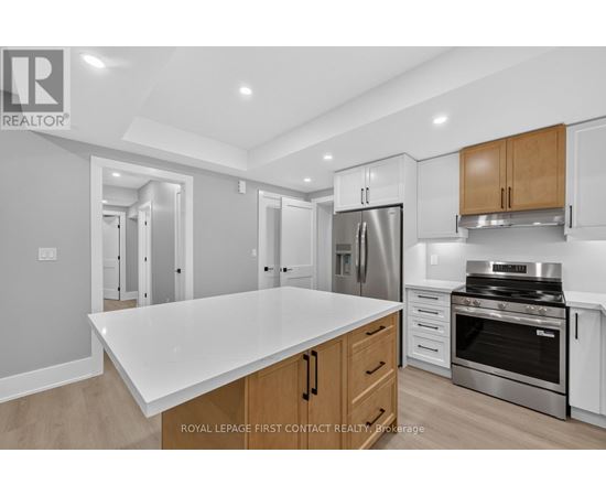 A modern kitchen with a white countertop and stainless steel appliances.