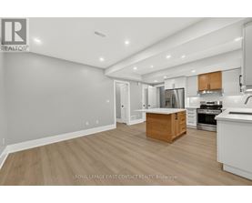 A well-lit kitchen with wooden floors and white walls.