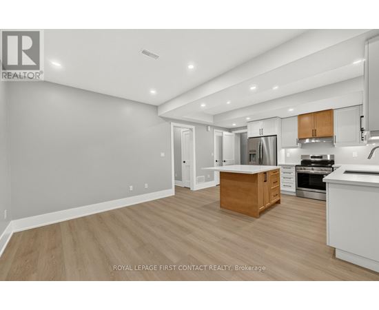 A well-lit kitchen with wooden floors and white walls.