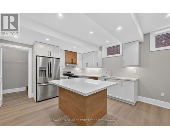 A modern kitchen with a wooden island and stainless steel appliances.