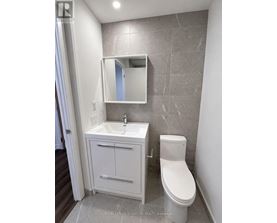 A white toilet sits next to a sink in a bathroom.
