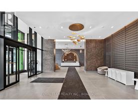 A modern and luxurious hallway with a chandelier and a fireplace.