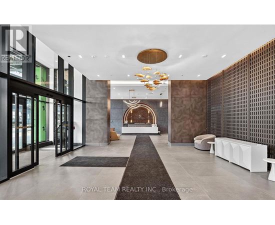A modern and luxurious hallway with a chandelier and a fireplace.