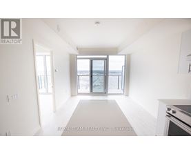 A spacious, empty room with a large window overlooking a beach.