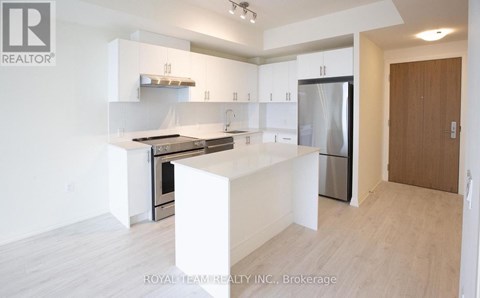 A white kitchen with a refrigerator, oven, and sink.