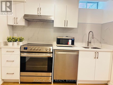 A kitchen with a stainless steel oven and microwave.