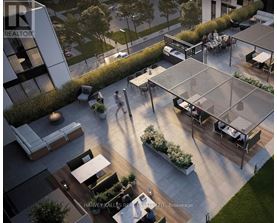 A modern outdoor seating area with a glass roof and people walking around.