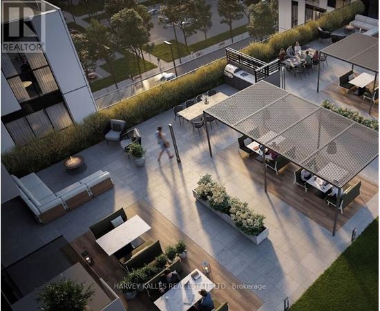 A modern outdoor seating area with a glass roof and people walking around.
