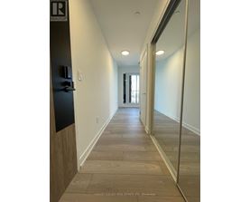 A long hallway with wood floors and white walls.