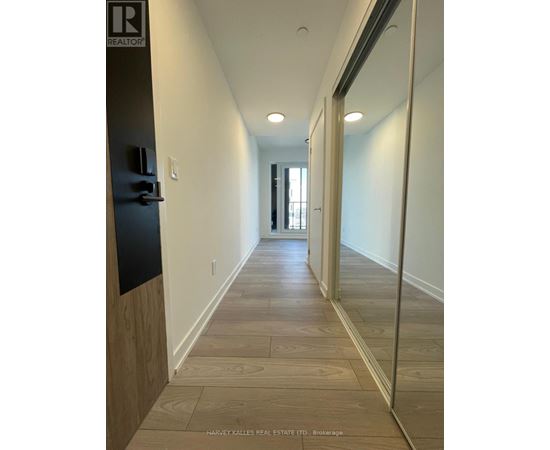 A long hallway with wood floors and white walls.