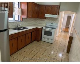 A kitchen with wooden cabinets and a white stove top oven.