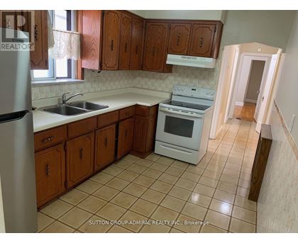 A kitchen with wooden cabinets and a white stove top oven.
