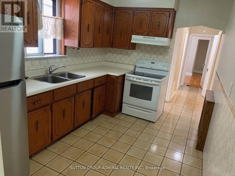 A kitchen with wooden cabinets and a white stove top oven.