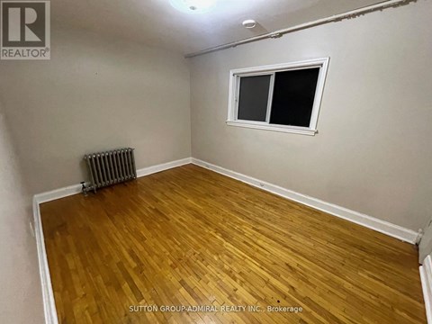 A room with a wooden floor and a window.