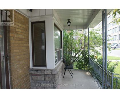 A balcony with a brick wall and a metal railing.