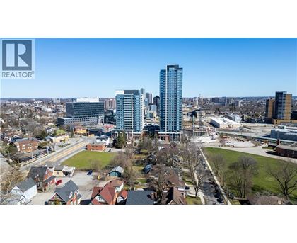 A cityscape with a mix of residential and commercial buildings, with a clear blue sky above.