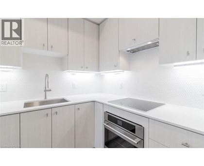 A modern kitchen with white cabinets and a stainless steel sink.