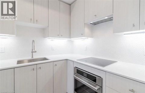 A modern kitchen with white cabinets and a stainless steel sink.