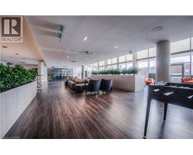 A modern office space with a long wooden floor and a green plant wall.
