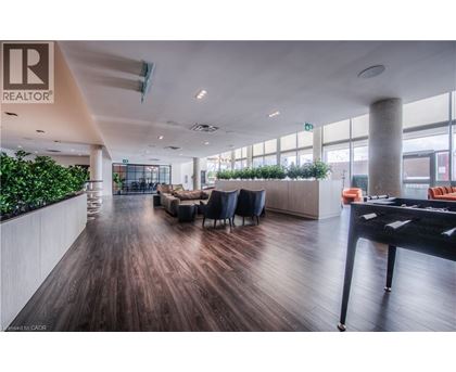 A modern office space with a long wooden floor and a green plant wall.