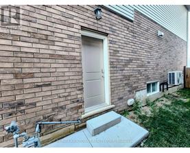 A brick house with a white door and a concrete step.