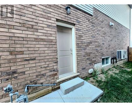 A brick house with a white door and a concrete step.