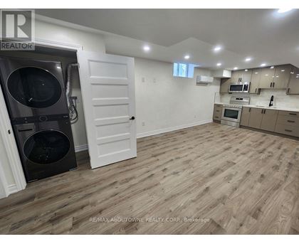 A kitchen with a white door and a black dishwasher.
