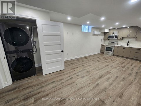 A kitchen with a white door and a black dishwasher.